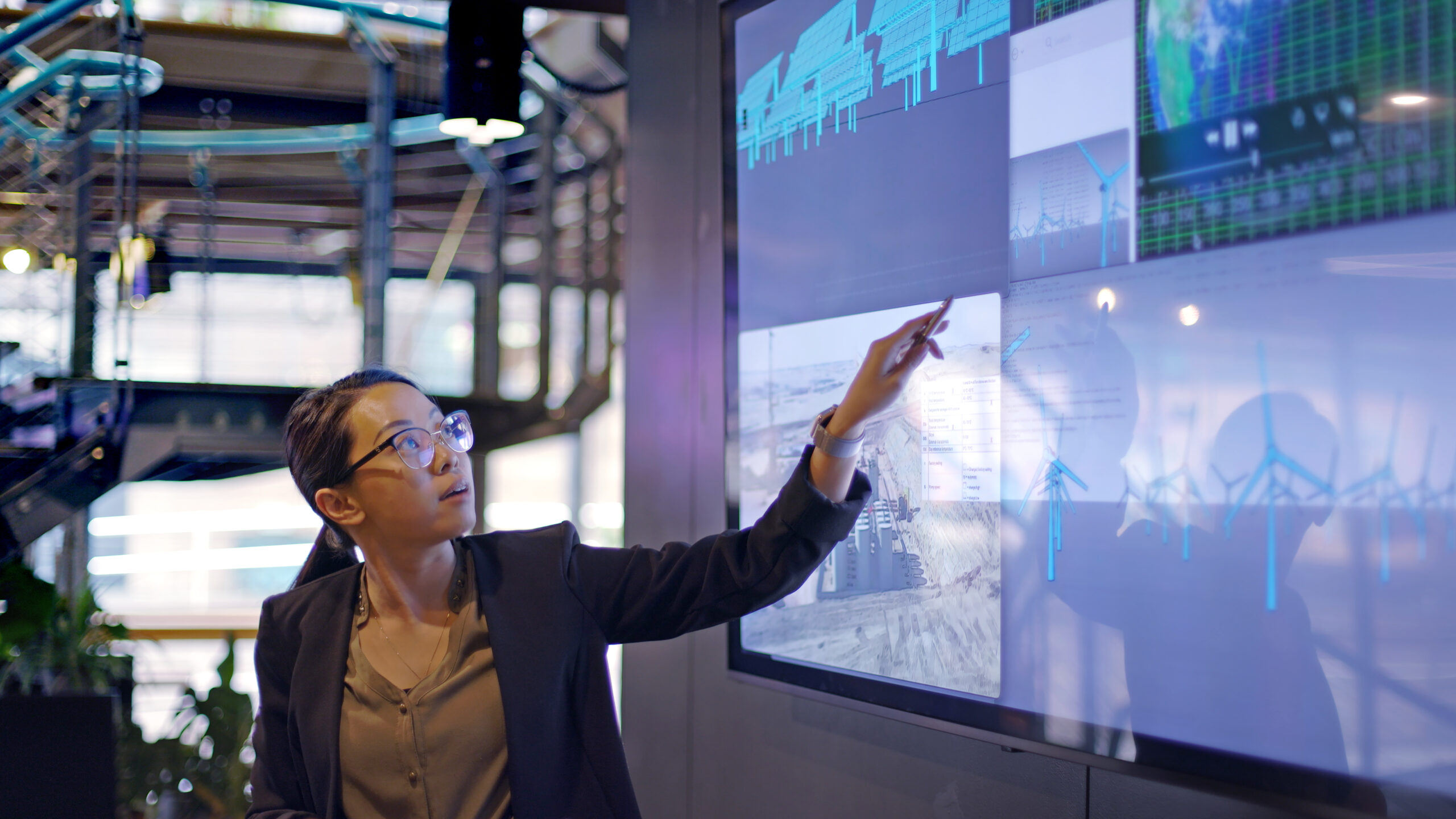 Female accountant points at digitalized chart during discussion on types of AI in accounting.