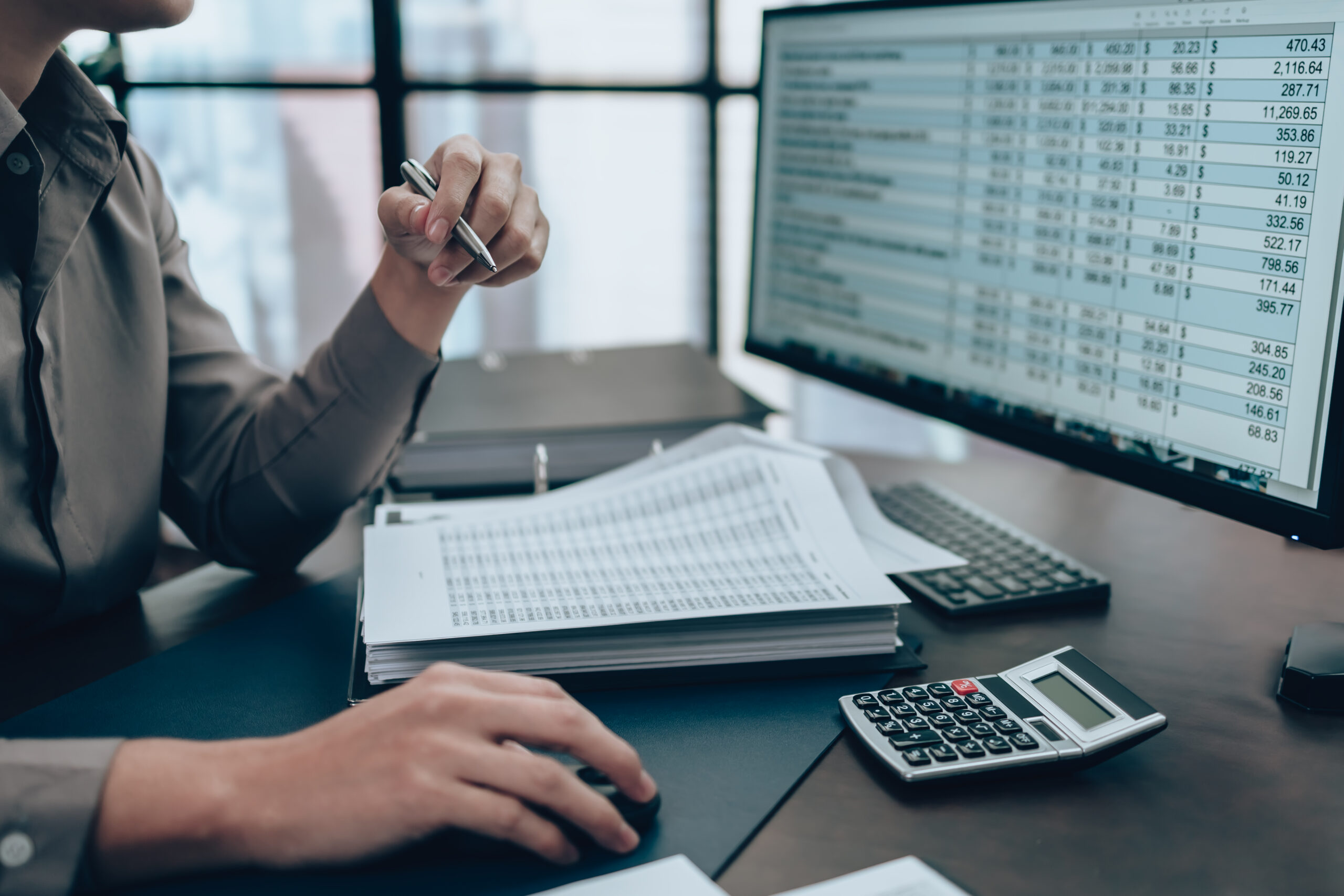 Man sitting at computer working on a nonprofit audit report.