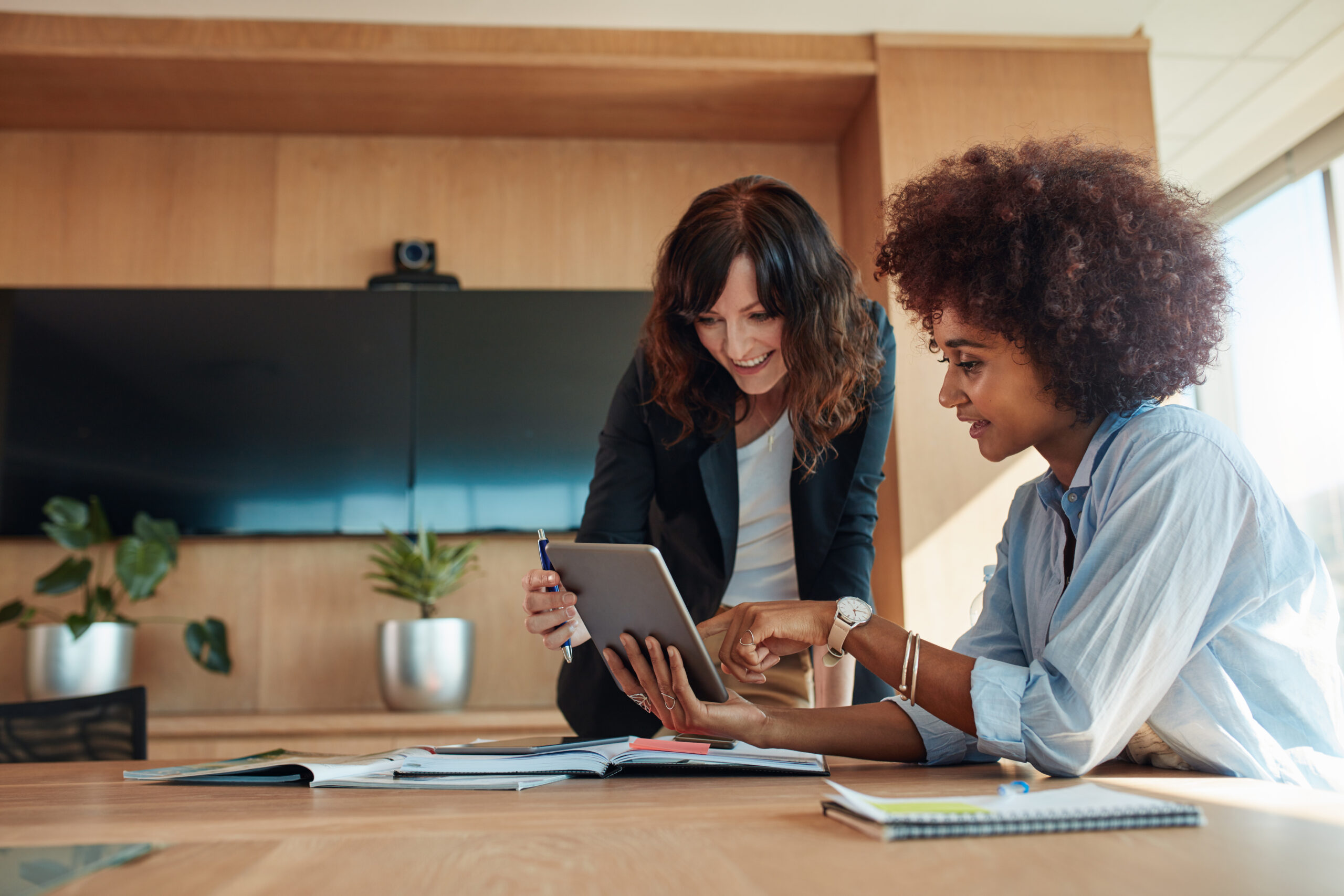 Two women looking at iPad, discussing the nonprofit accounts payable process.